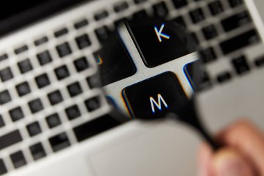 close-up view of magnifying glass and laptop keyboard, selective focus clipart
