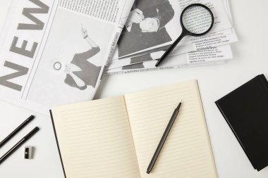 Grey dizüstü bilgisayarlar, gazete, ofis malzemeleri ve Büyüteç Camı üstten görünüm