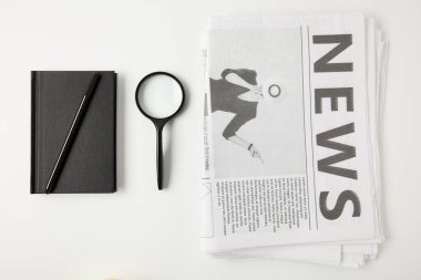 top view of notebook with pen, magnifying glass and newspapers isolated on grey  clipart