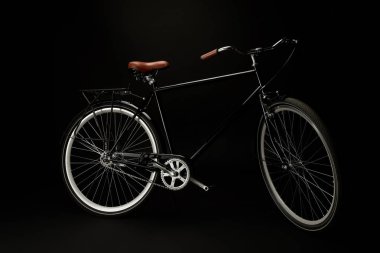 side view of comfortable vintage bicycle isolated on black  clipart