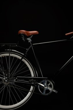 wheel, saddle and pedals of classic bicycle isolated on black clipart