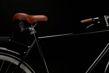 close-up view of saddle and handlebar of classic bicycle isolated on black clipart