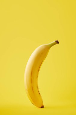 close up view of fresh banana isolated on yellow clipart