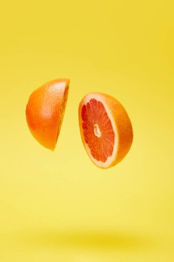 close up view of cut grapefruit isolated on yellow clipart