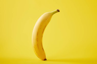 close up view of fresh banana isolated on yellow clipart