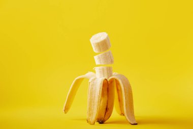 close up view of ripe cut banana isolated on yellow clipart