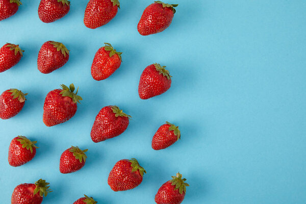 top view of arranged fresh strawberries isolated on blue