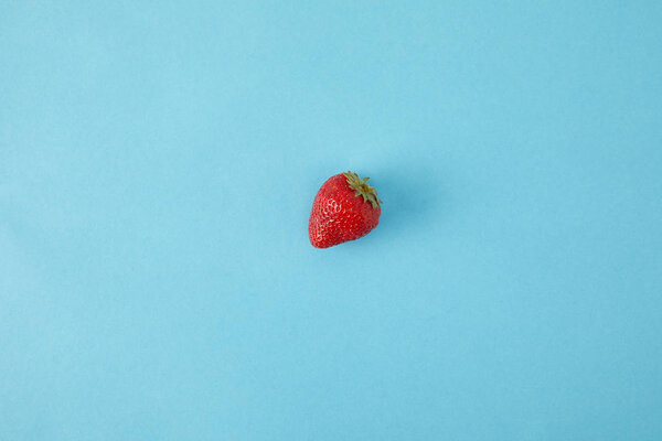top view of ripe strawberry isolated on blue