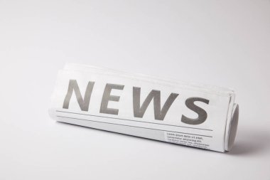 Beyaz arka plan üzerinde yalan gazete haddelenmiş
