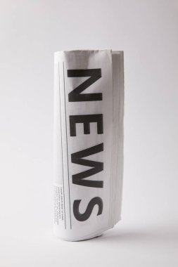 rolled daily newspaper on white background clipart