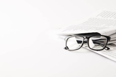 pile of newspapers with eyeglasses, on white background with copy space clipart