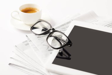 eyeglasses, coffee cup, digital tablet and pile of newspapers, on white clipart