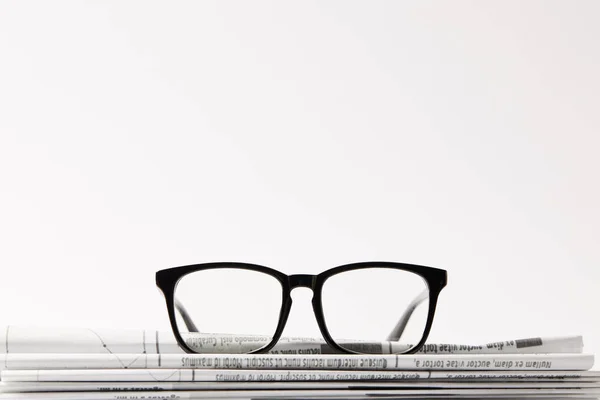 Close Óculos Pilha Jornais Isolado Fundo Branco Com Espaço Cópia — Fotografia de Stock