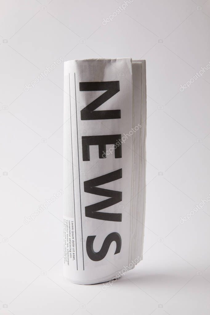 rolled daily newspaper on white background