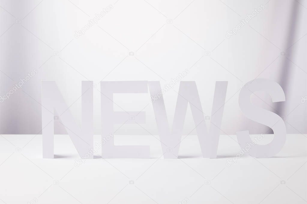 minimalistic word news made of paper, on white background