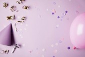 pohled shora konfety kusů, balón a párty čepice na fialovou povrchu
