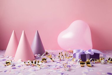 kalp şekilli balon, parti şapkaları ve menekşe masa üzerinde sunmak