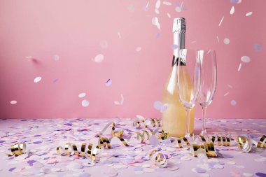 bottle of champagne, glasses and falling confetti pieces on violet surface clipart