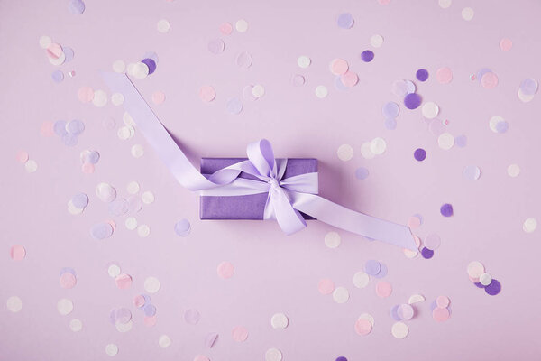 вид сверху на одну фиолетовую коробку и конфетти на поверхности
