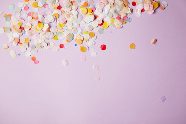 top view of tiny confetti pieces on violet surface