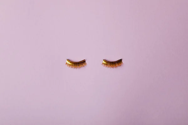 Top View Stylish Golden False Eyelashes Isolated Purple — Stock Photo, Image