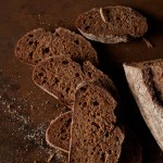 Bovenaanzicht van brood en sneetjes brood op rustieke metalen tafel