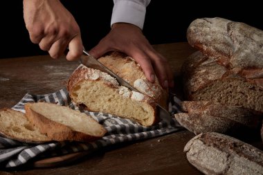 bıçak, ahşap masa üstünde çul üzerinde atış erkek baker kesme ekmek kırpılmış