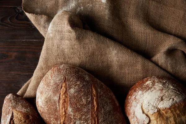 Draufsicht Auf Verschiedene Brotsorten Und Sacktuch Auf Holztisch — Stockfoto