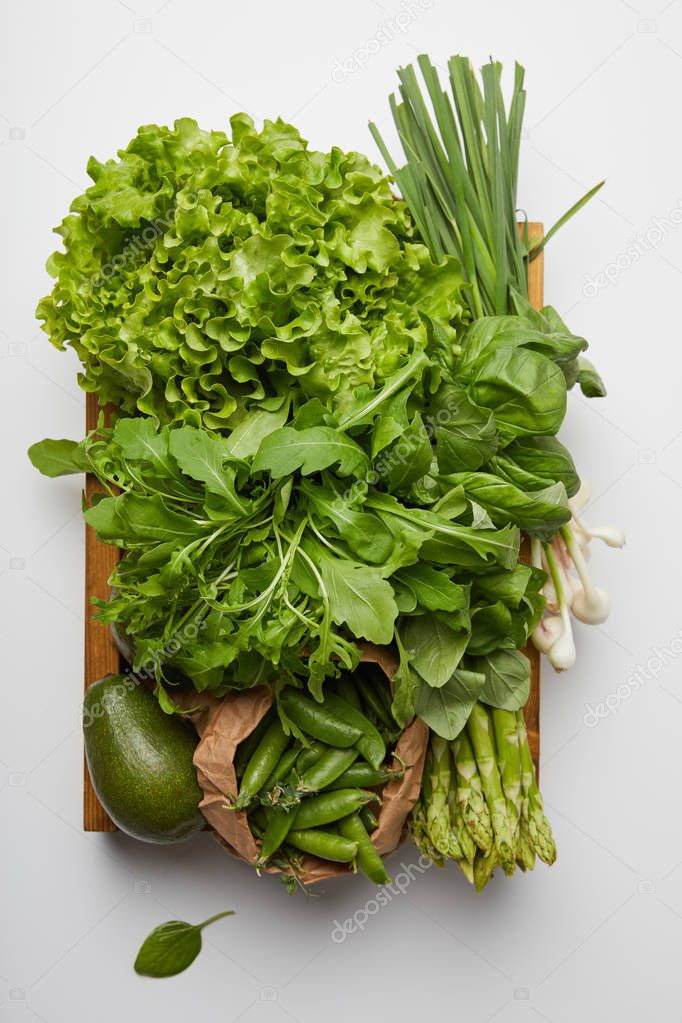 top view of various ripe vegetables in box on white surface