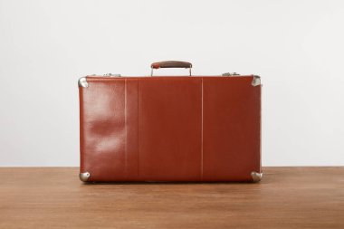 Vintage brown leather suitcase on wooden table