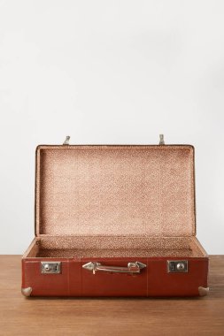 Old open brown empty suitcase on wooden table