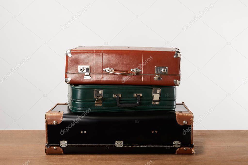 Stacked old leather travel bags on wooden table