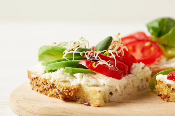 close-up shot of delicious sandwich with avocado, tomato and pea shoots