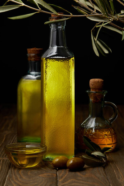 bottles of various olive oil on wooden surface