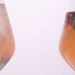 Gedeeltelijke weergave van twee glazen met limonade geïsoleerd op een grijze achtergrond