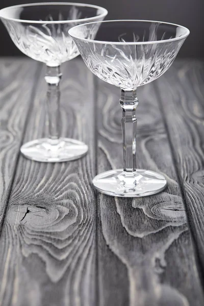 two empty glasses on grey wooden tabletop