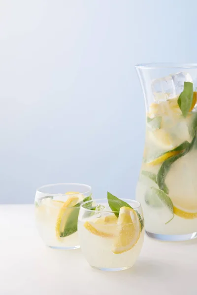 水差し レモネードとミントの葉 氷とレモン スライスを青い背景の つのグラス  — 無料ストックフォト