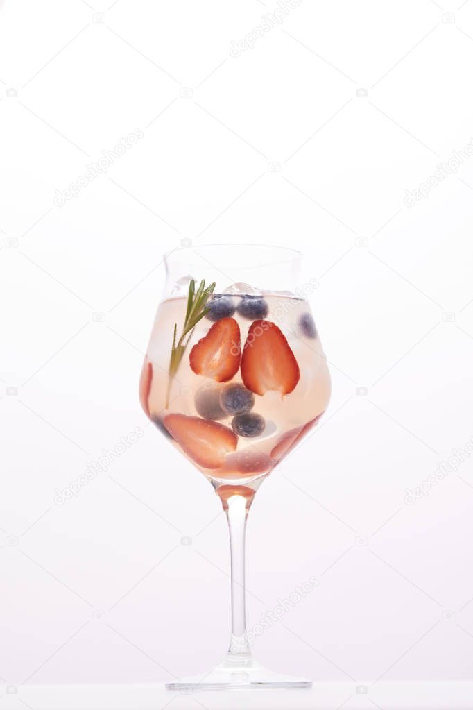 glass of lemonade with rosemary, blueberries and strawberries isolated on white background 