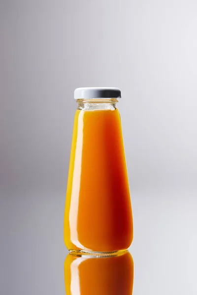 Flaska Med Färsk Apelsinjuice Reflekterande Yta — Stockfoto