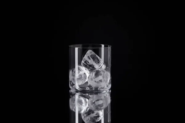 Único Vidro Com Cubos Gelo Superfície Reflexiva Isolado Preto — Fotografia de Stock