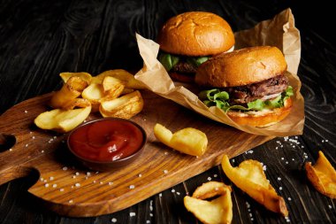 Burger ve kesme tahtası üzerinde soslu patates ile cazip lokanta lokanta