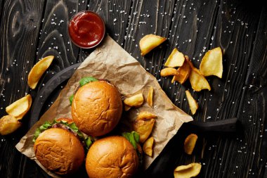 Ahşap masa üzerinde hamburger ve patates kızartması ketçap ile üstten görünüm