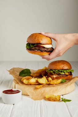 Hamburger patates kızartması ile ayarla diner üzerinde tutan el