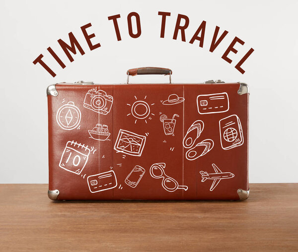 Vintage brown leather suitcase with icons and lettering - Time to travel