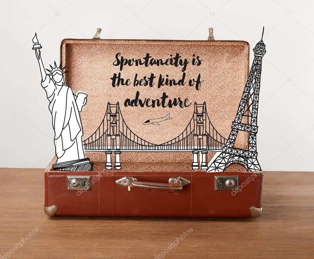 Open vintage travel bag with illustration and lettering - Spontaneity is the best kind of adventure