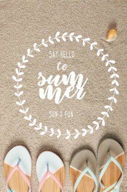 flat lay with summer flip flops and seashell on sand with 
