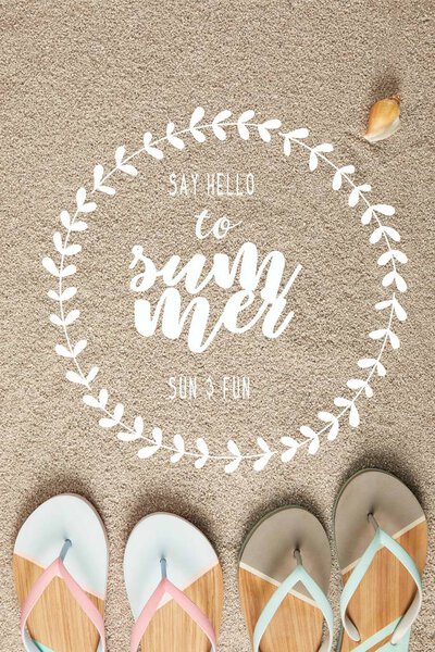 flat lay with summer flip flops and seashell on sand with "say hello to summer" lettering in floral frame