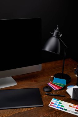 ahşap yüzey üzerinde renkli palet, boş bilgisayar ekranı, lamba ve grafik tablet grafik tasarımcı çalışma alanı'nın görünümünü kapat