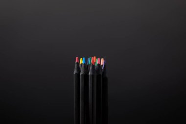 close up view of arranged pencils on black wall backdrop clipart
