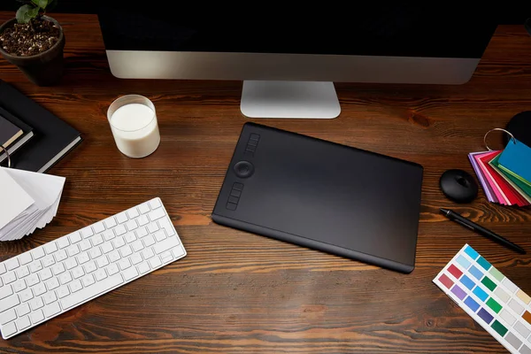 木製卓上型のパレット ミルクのガラス グラフィック タブレットとコンピューター画面でグラフィック デザイナー職場のビューをクローズ アップ — ストック写真